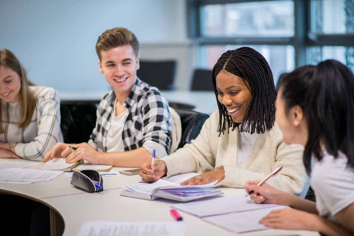 Students in a classroom working together and smiling